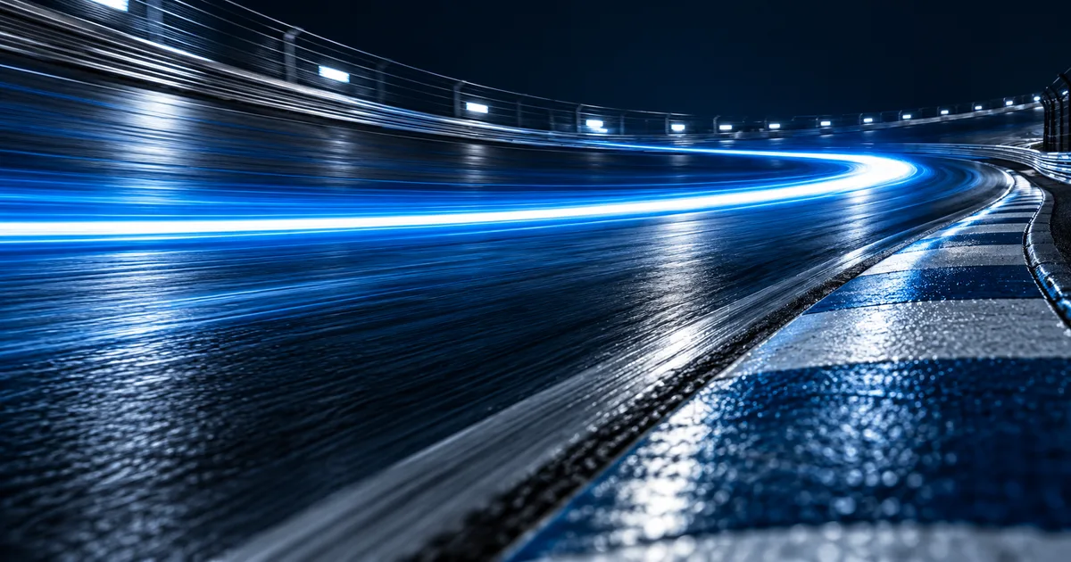 A blue light trail sweeping around a dark curved track.